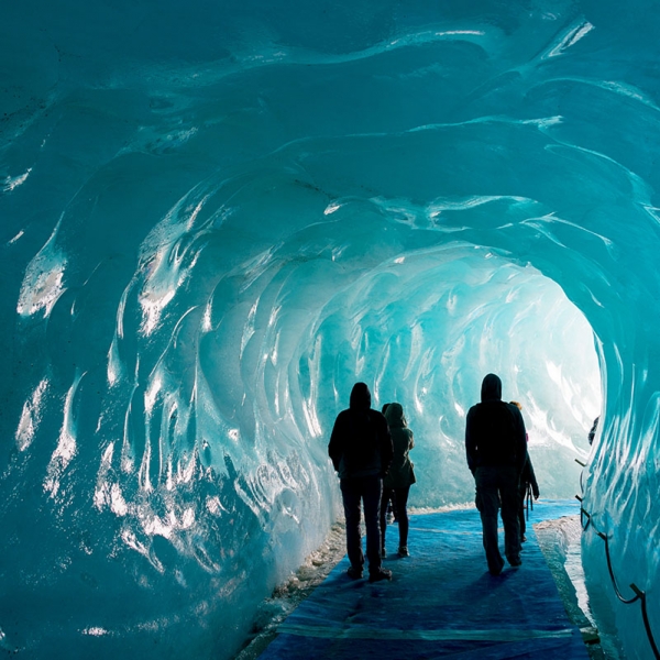 Silhouettes of people visiting thee ice cave of the Mer de Glace glacier, in Chamonix Mont Blanc Massif, The Alps, France